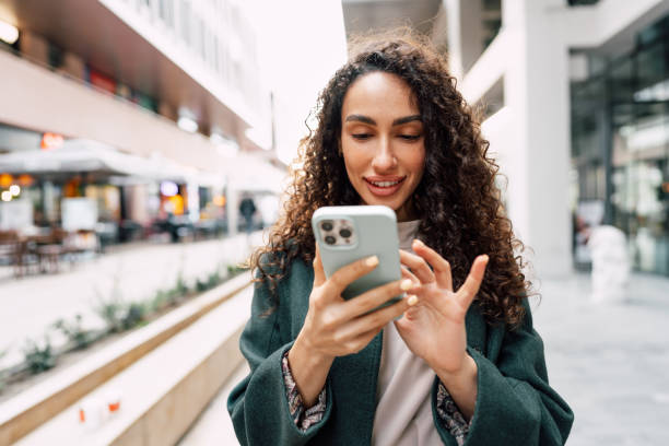 Young woman reading a message or using the phone in the city close up